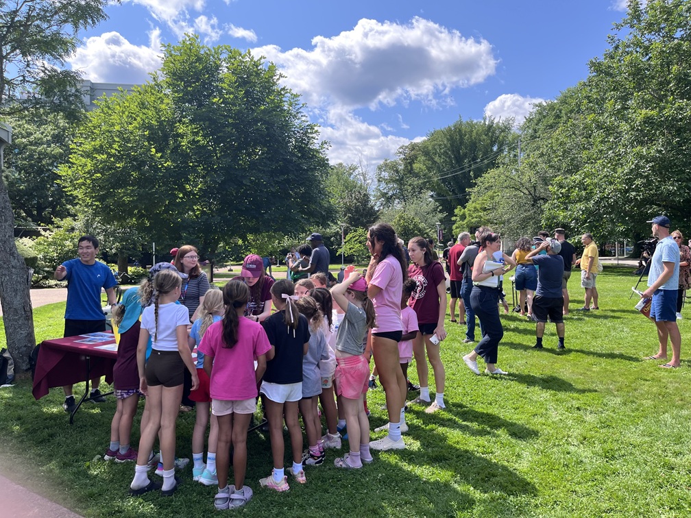 People standing around a table on the grass