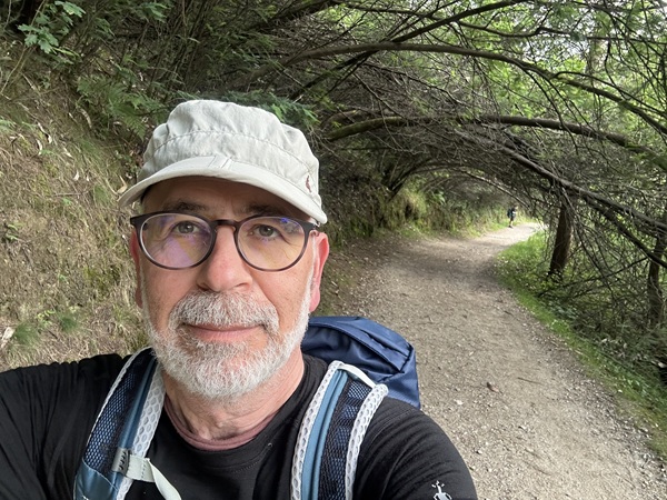Jeff Webb posing for a photo, outdoors with green background