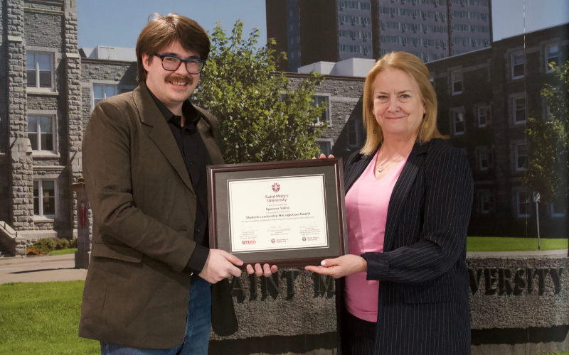 Spencer accepts a leadership award from the Dean of Arts