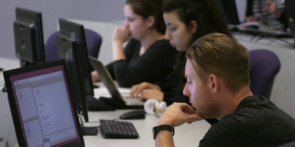 Students concentrate on computer screens.