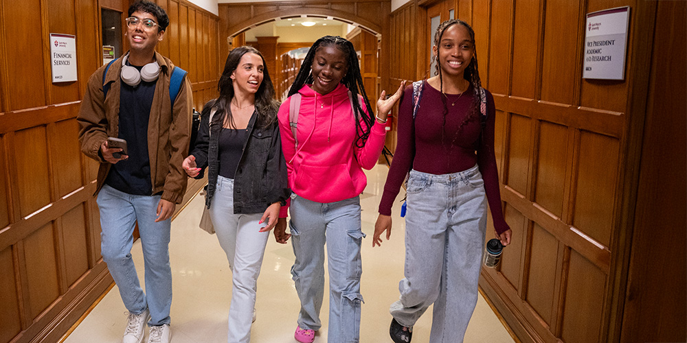 A group of students are walking Walking down the hallway in McNally